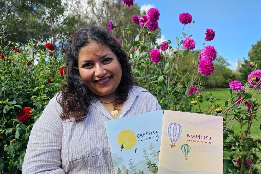 Whistle and Page creator holding her books Grateful and Bountiful in a garden